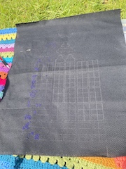 First dark blue stitches with panel outlines, outside on a sunny day