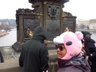 Man with comedy pig hat by old monument