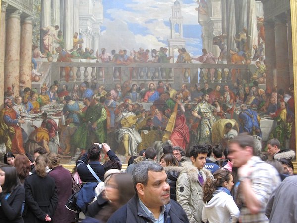 Lots of people in front of a picture of the Last Supper