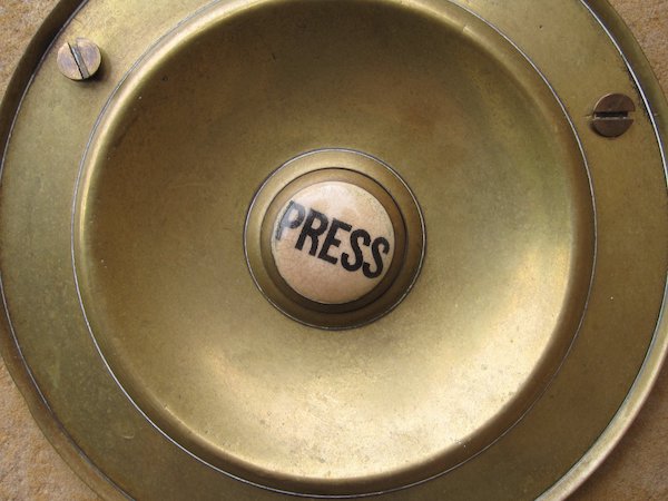 An old fashioned button with the word Press