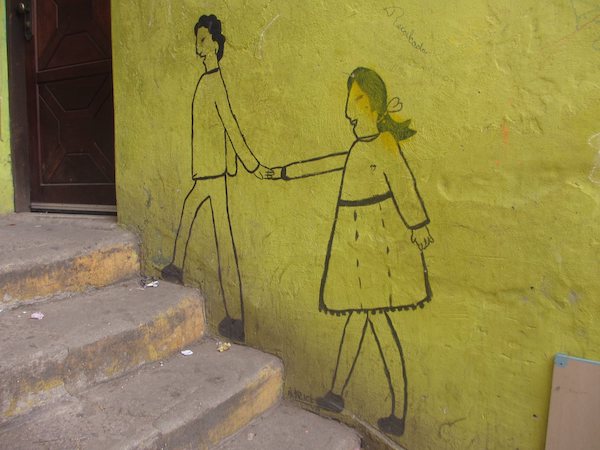 Figures holding hands drawn on a slum wall