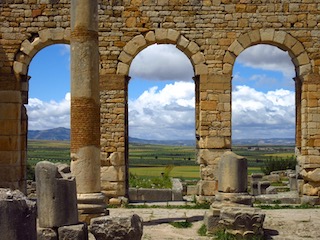 Three basilica arches with plains visible through them