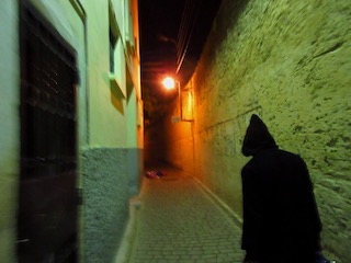 Porter in black cloak in alleyway at 4am